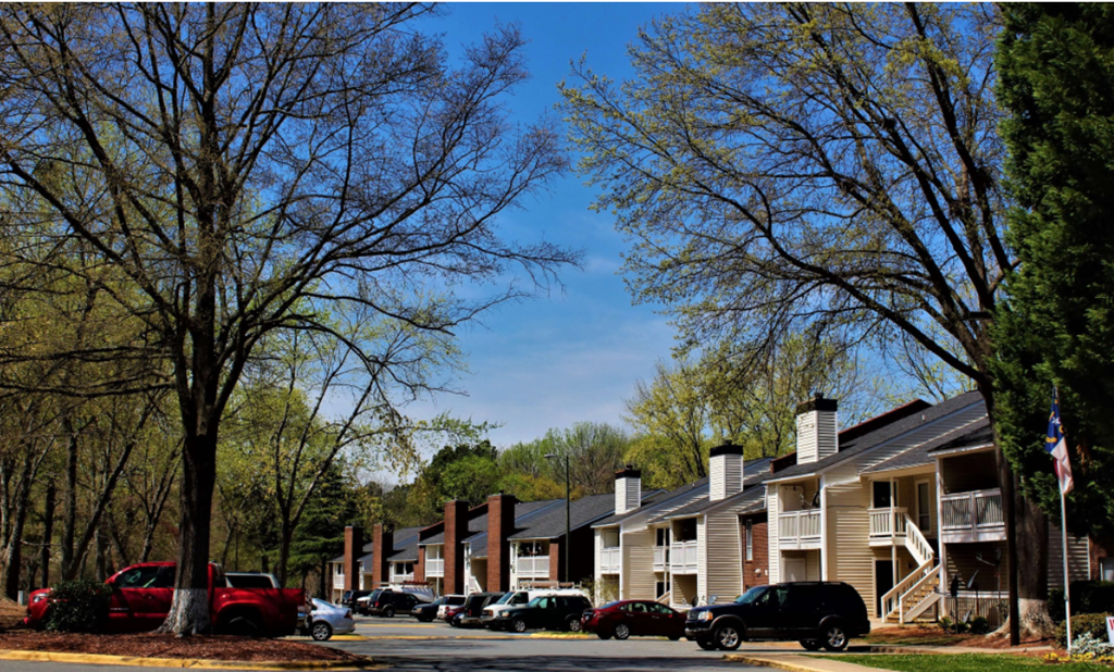 an apartment building with cars parked in front of it