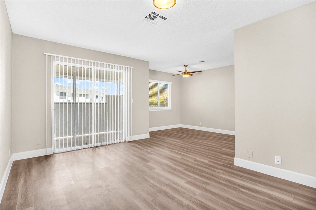 a living room with hardwood floors and a ceiling fan
