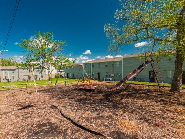 a simple two story home with green shutters and a red front door