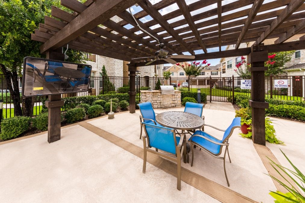 a patio with a table and chairs and a tv