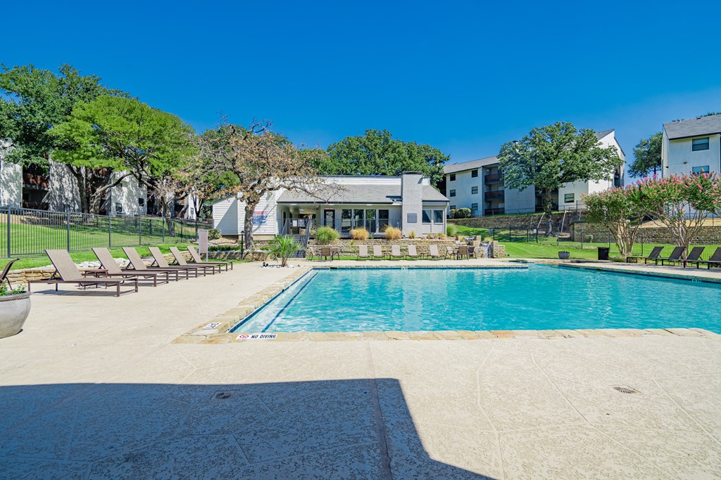 a render of a swimming pool with trees and buildings in the background