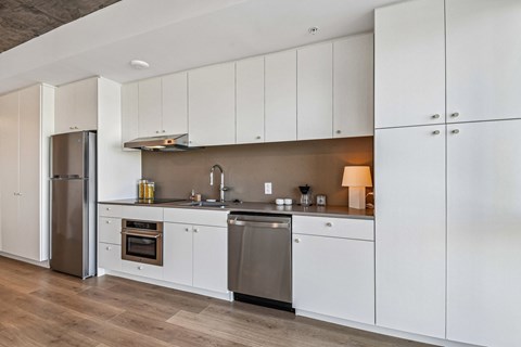 A modern kitchen with white cabinets and stainless steel appliances.
