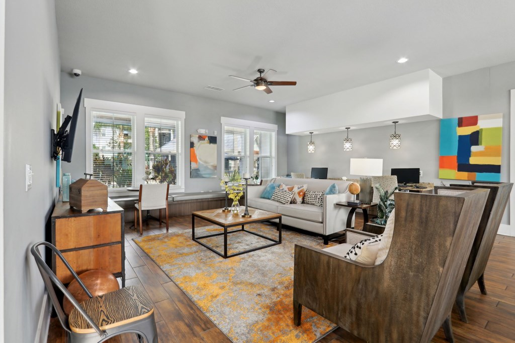 A living room with a white couch and a wooden chair.