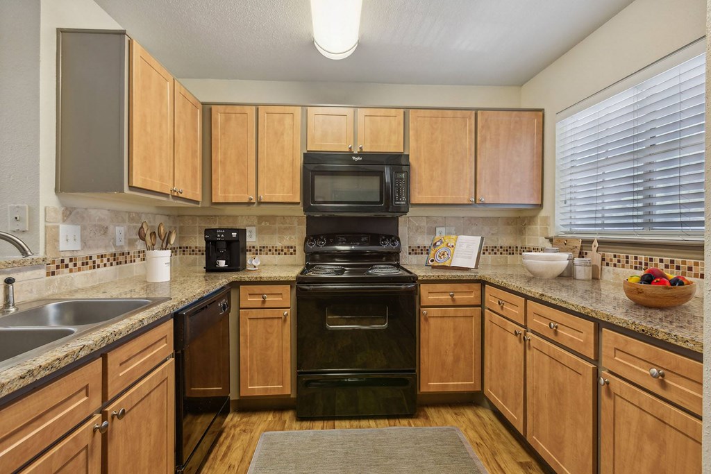 A kitchen with wooden cabinets and a black stove top oven.