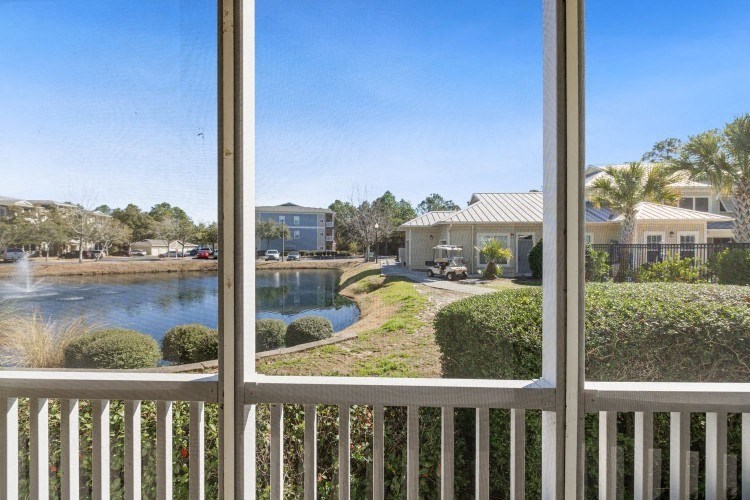 a balcony with a view of a pond and a house