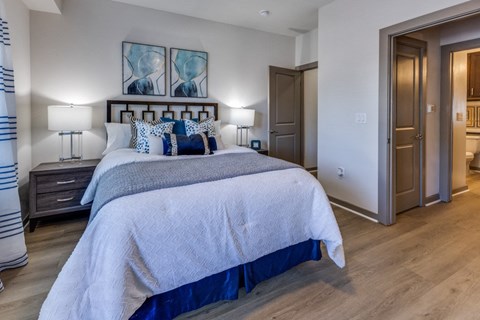 A bedroom with a large bed and a painting above it.