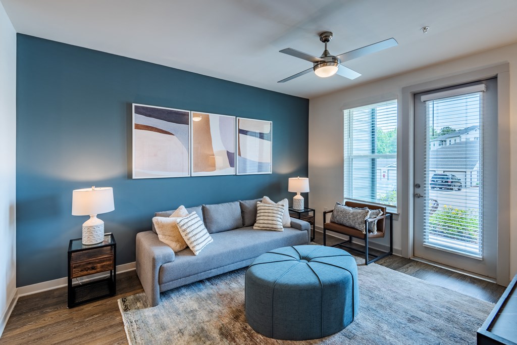 a living room with a blue accent wall and a blue couch