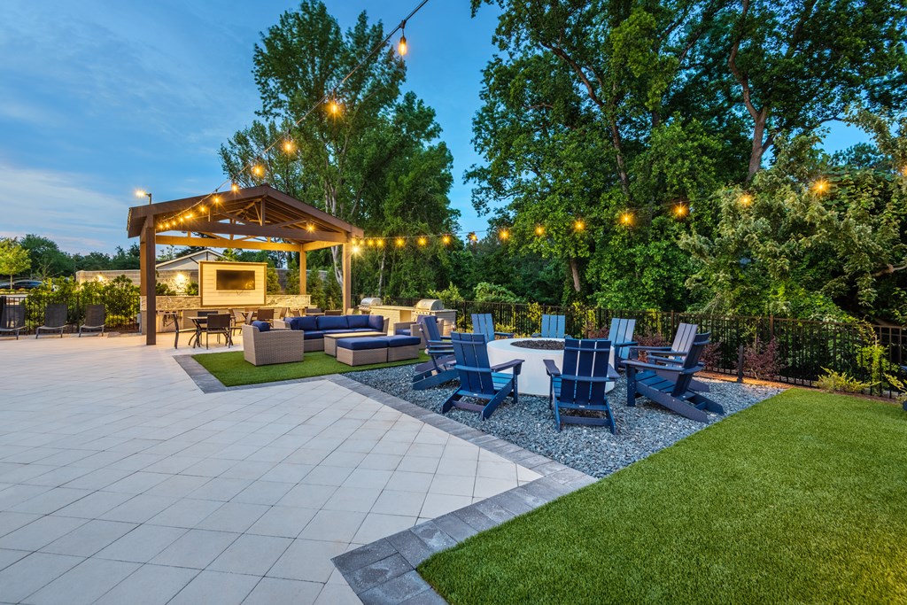 a patio with chairs and a table and a pavilion with lights