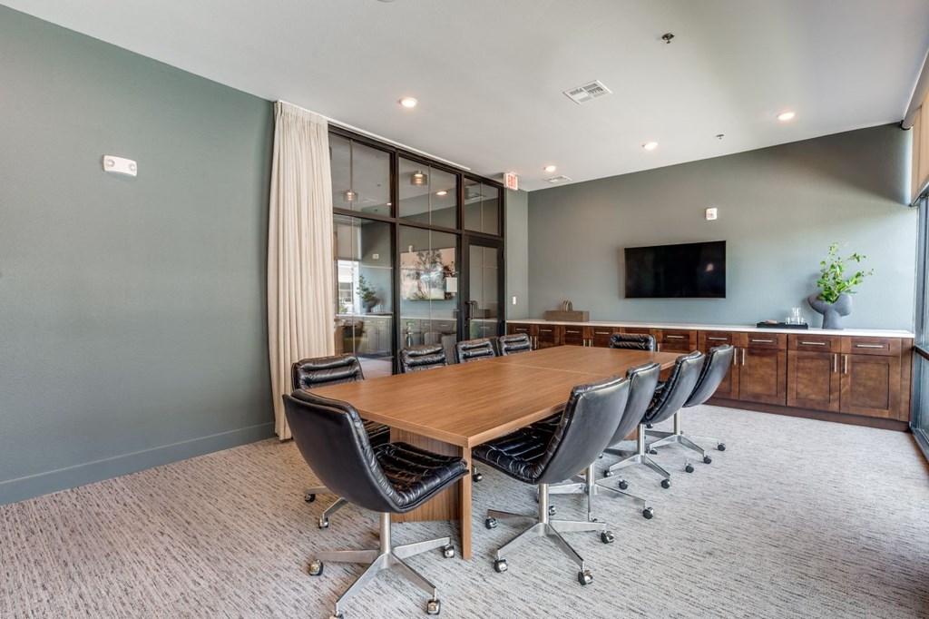 a conference room with a large wooden table and chairs