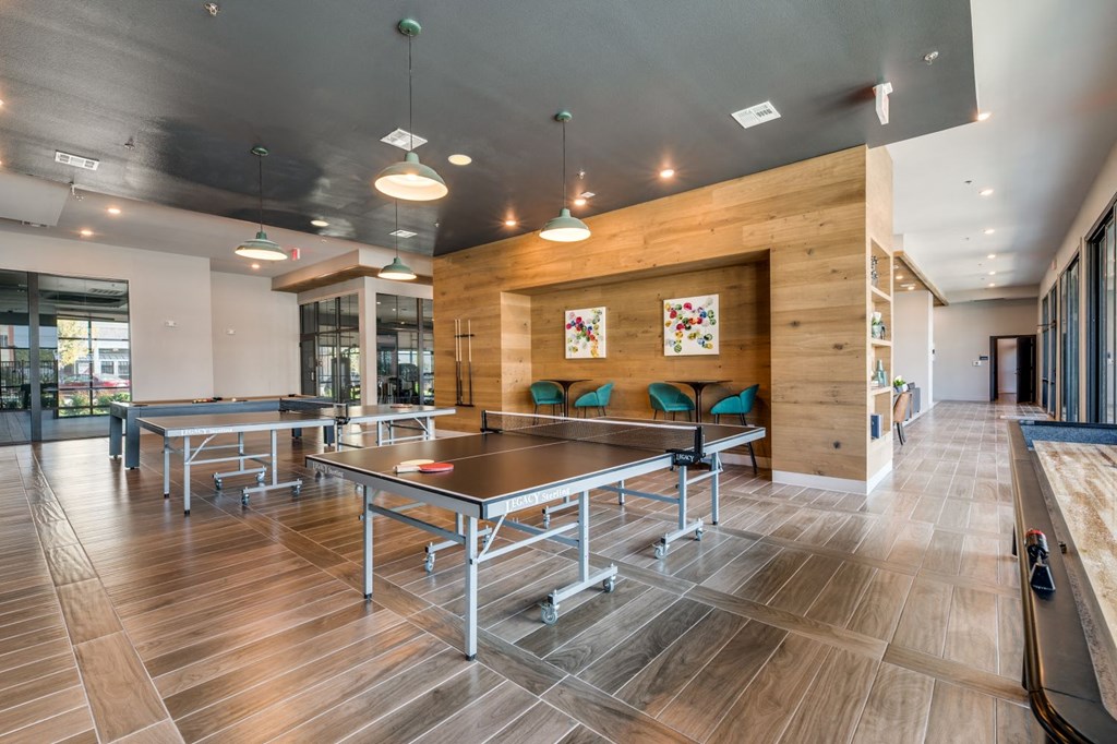 two ping pong tables in a large room with wood floors