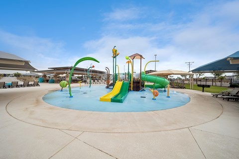 A playground with a blue and green slide and a yellow and green climbing structure.