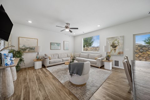 A living room with a grey sofa set and a wooden floor.
