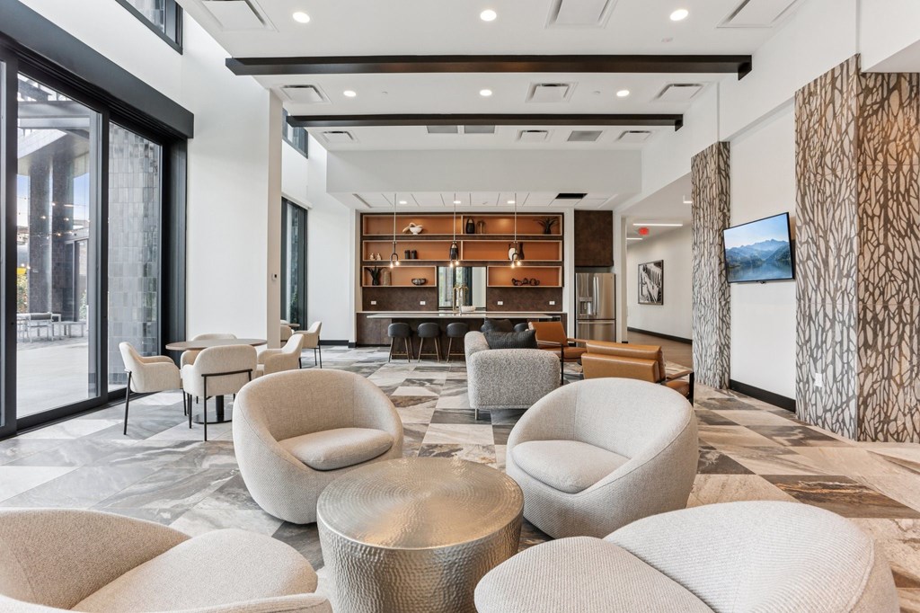 A modern living room with a large sofa and a TV on the wall.