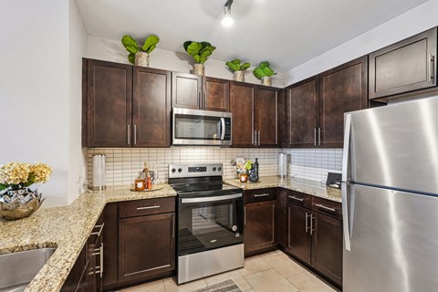A kitchen with brown cabinets and a stainless steel refrigerator.