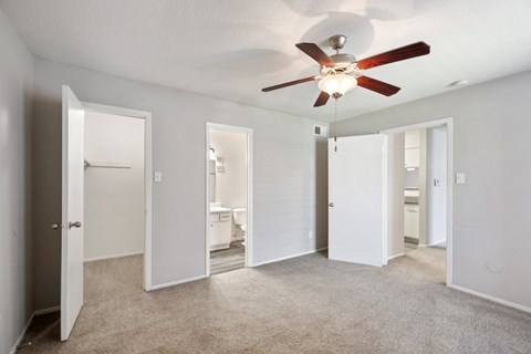 an empty room with mirrored doors and a ceiling fan