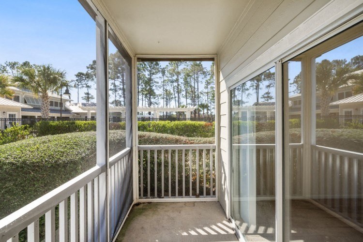 the view from the porch of a home with large glass windows