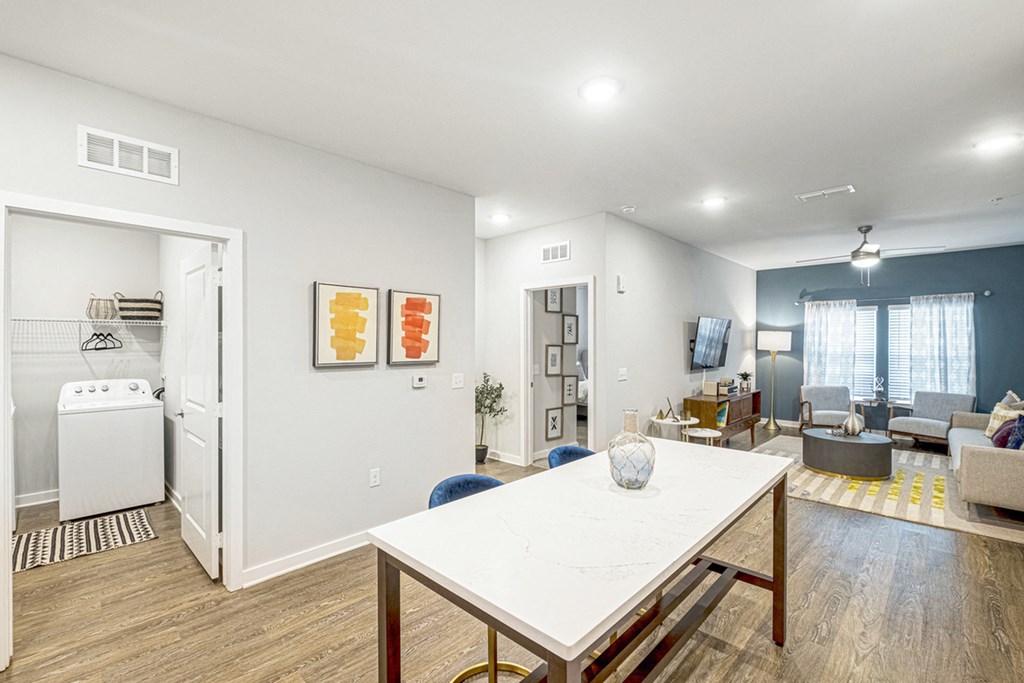 a living room with a white table and a dining room