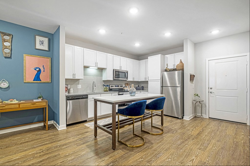 a kitchen with white cabinets and a table with two chairs