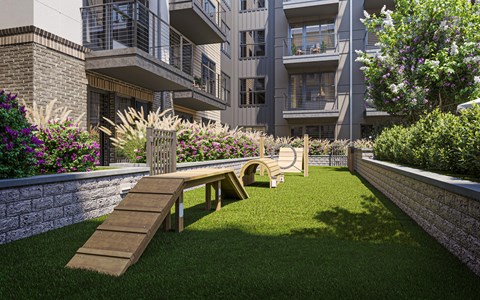 a seating area in a garden in front of an apartment building