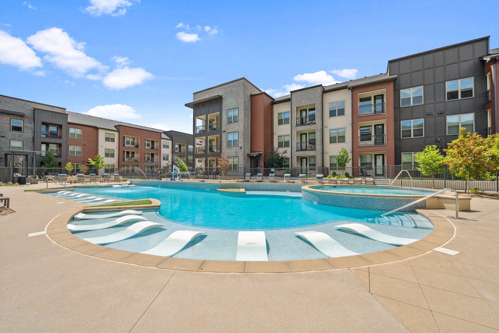 an outdoor pool with an apartment building in the background