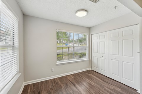 A room with a white door and a window with blinds.