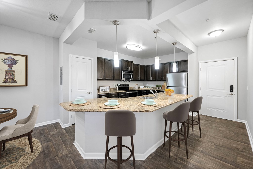 an open kitchen and dining area with a marble counter top