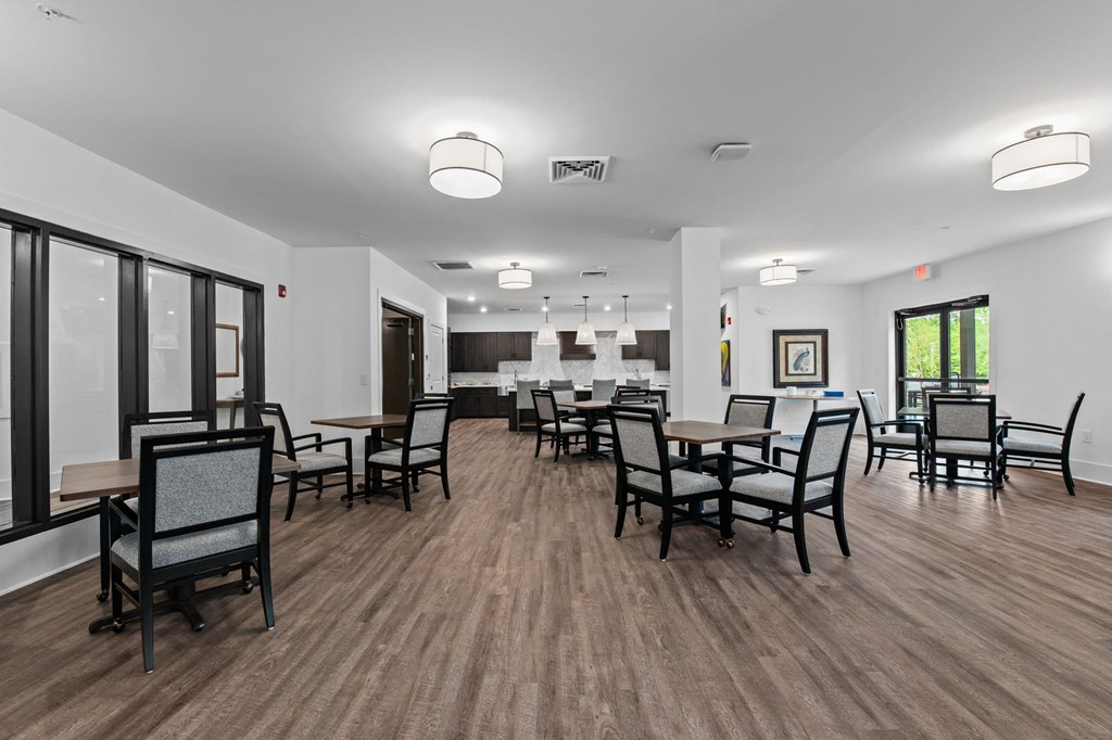 a large dining room with tables and chairs and a kitchen