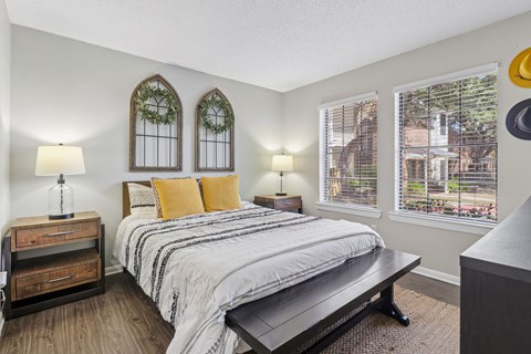 A bedroom with a bed, nightstand, and window.