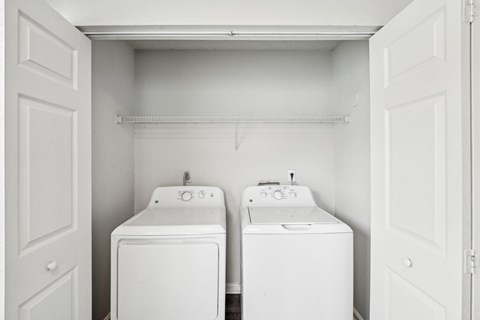 A small laundry room with a washer and dryer in it.