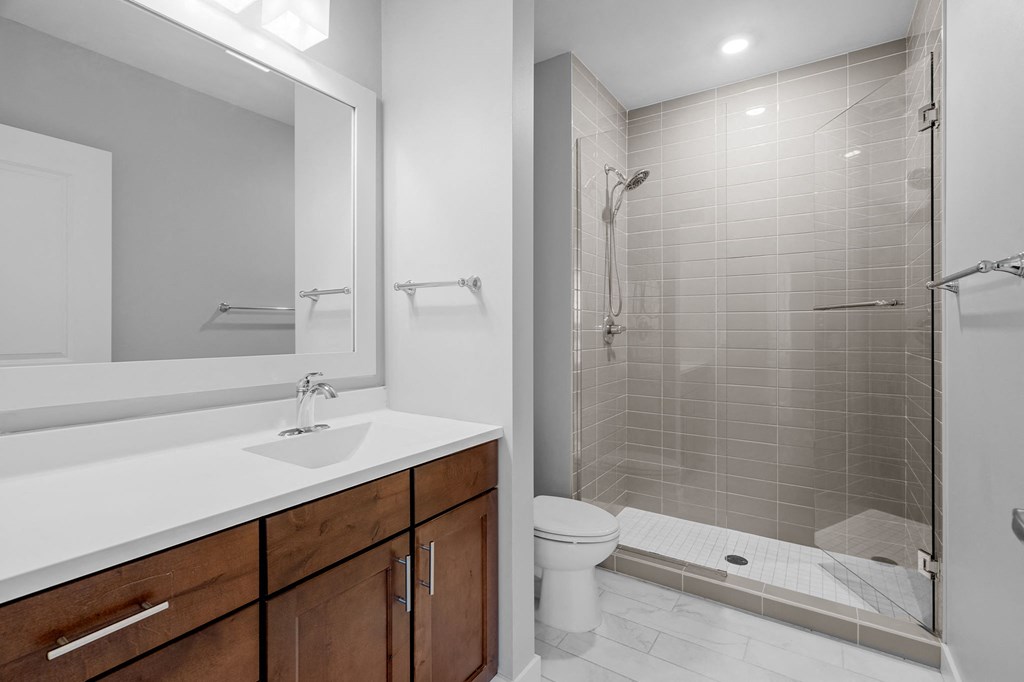 a bathroom with a shower sink and toilet and a mirror