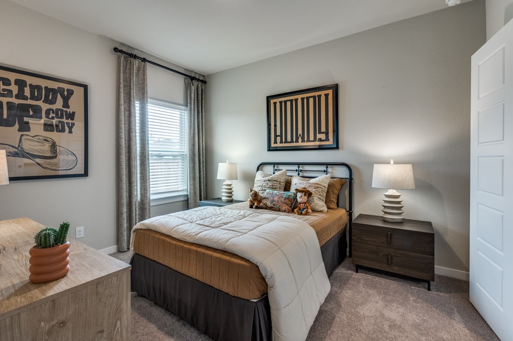 A bedroom with a bed, nightstand, and a poster on the wall.