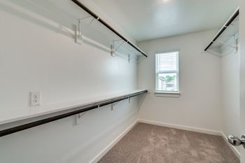 A room with a window and a carpeted floor.