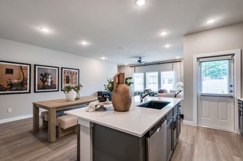 A kitchen with a table and chairs in front of a window.