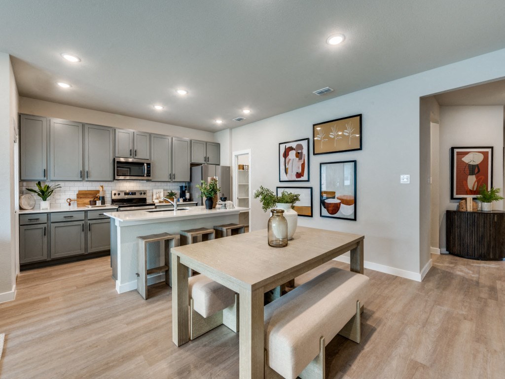 A modern kitchen with a dining table and chairs.