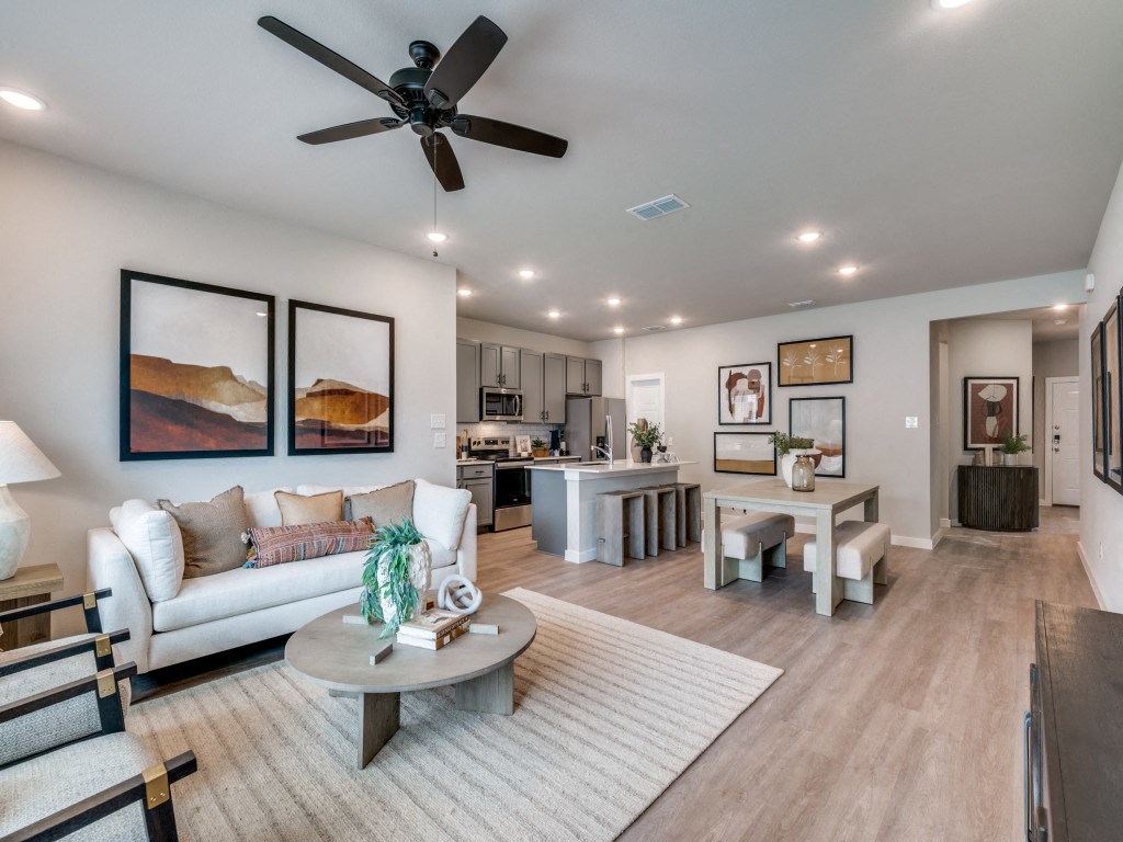 A living room with a white couch, a coffee table, and a ceiling fan.