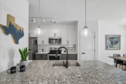 A kitchen with a granite countertop and a sink.