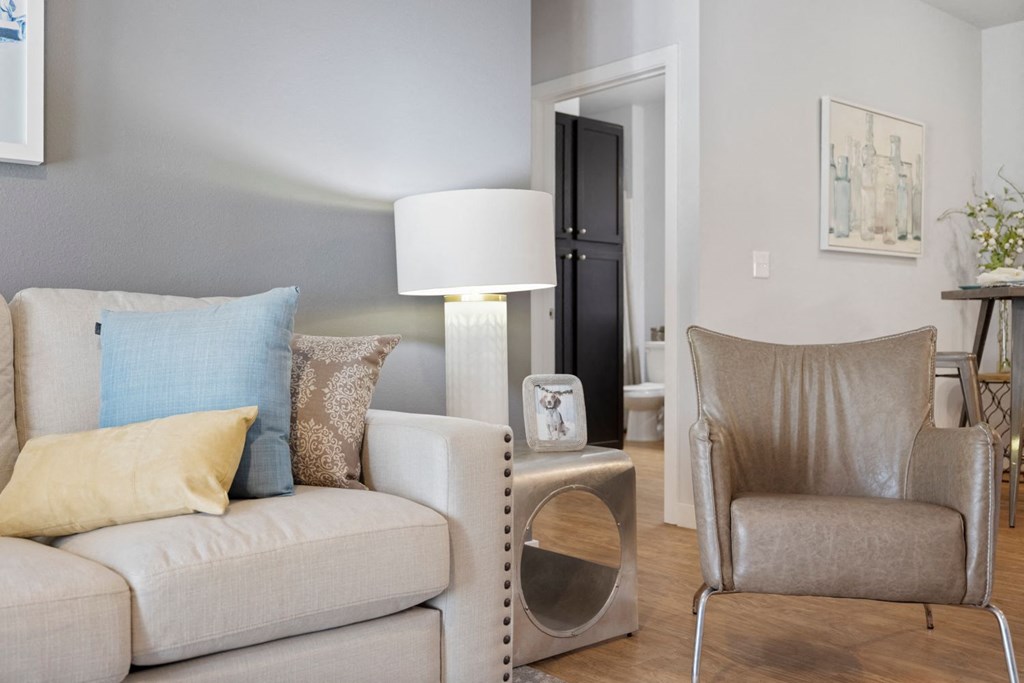 A living room with a white couch and a grey chair.