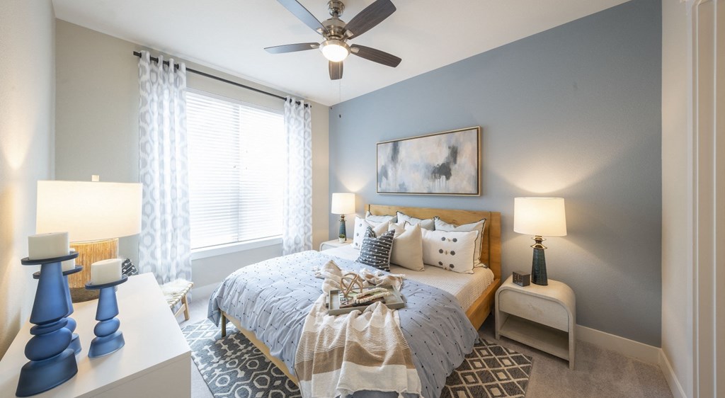 a bedroom with a bed and a ceiling fan