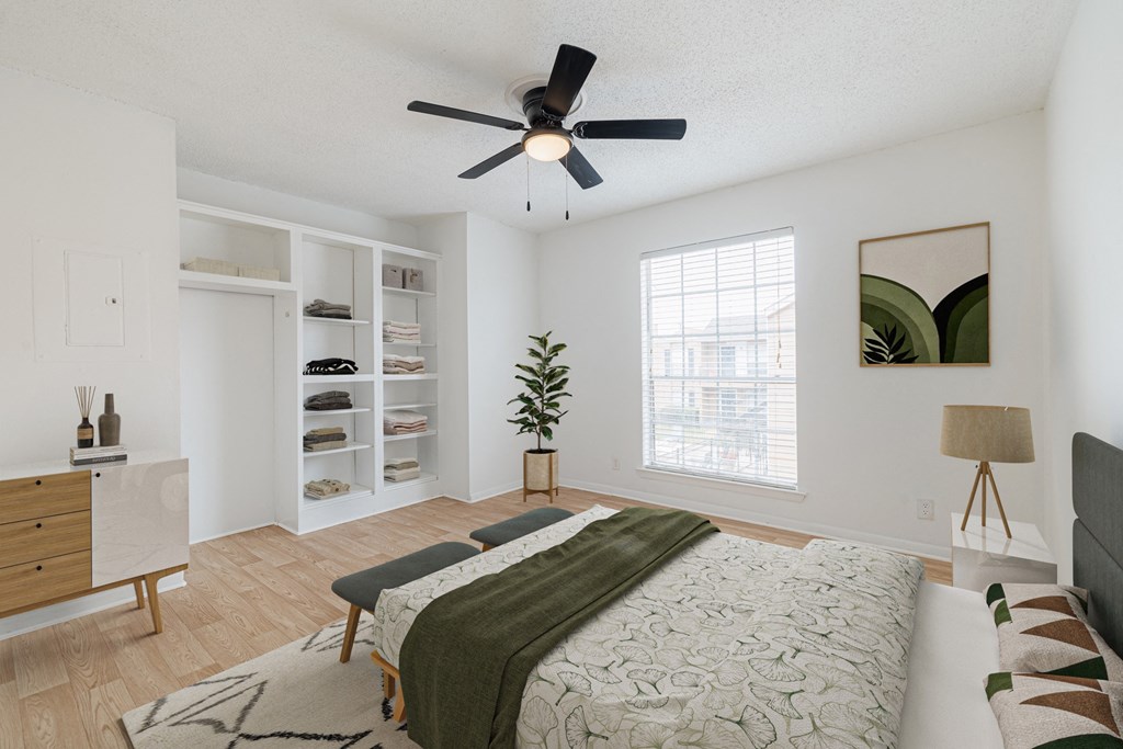 a bedroom with a large bed and a ceiling fan