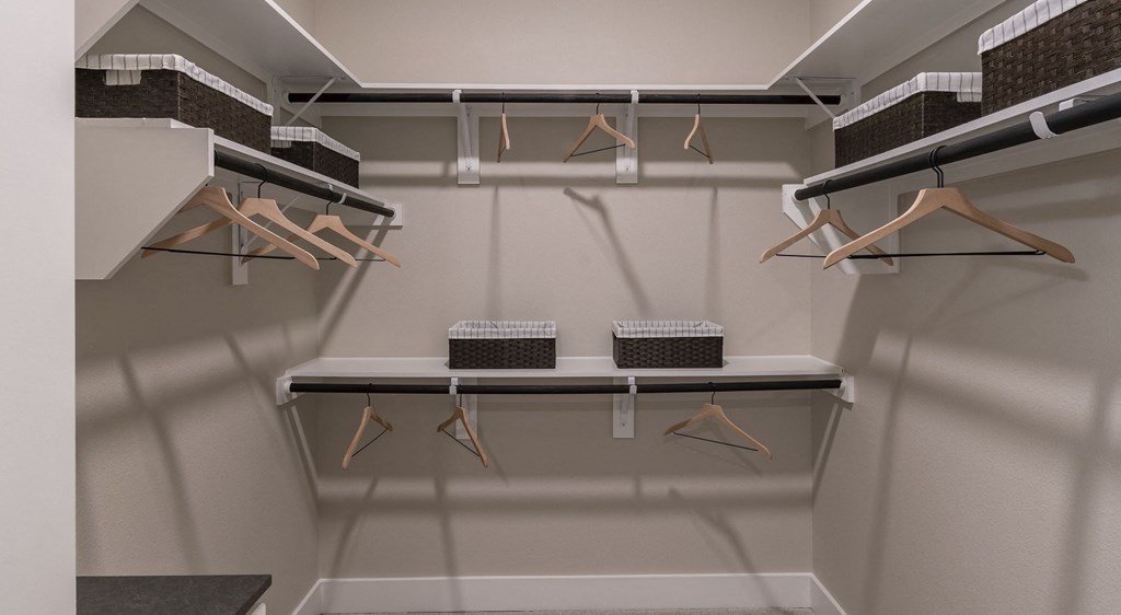 a walk in closet with shelves and hangers