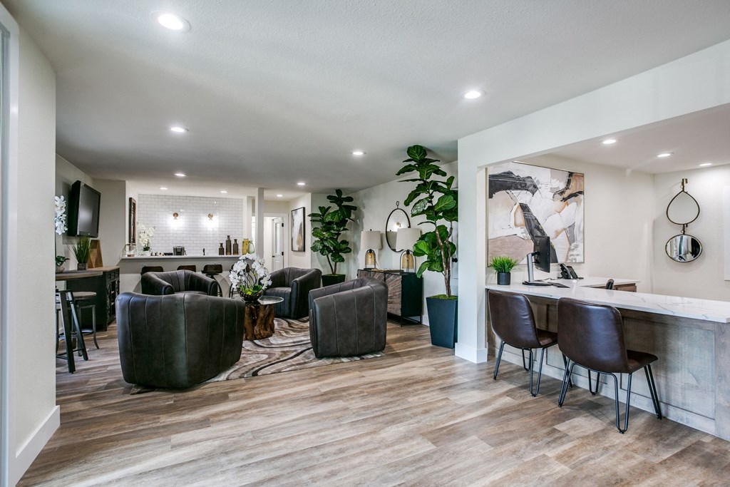 a living room with chairs and a bar and a kitchen