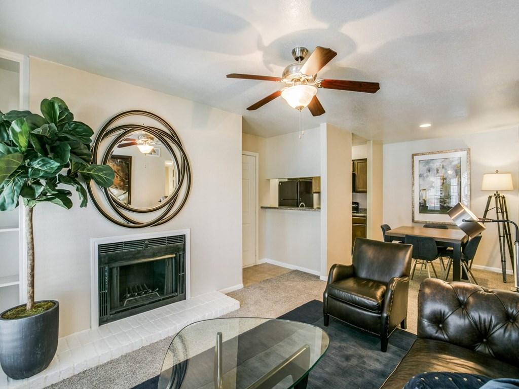 a living room with a fireplace and a ceiling fan