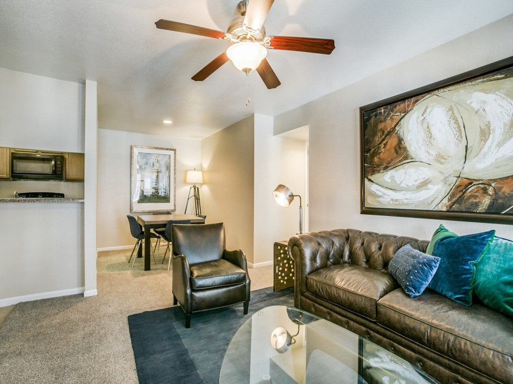 a living room with a couch and a ceiling fan