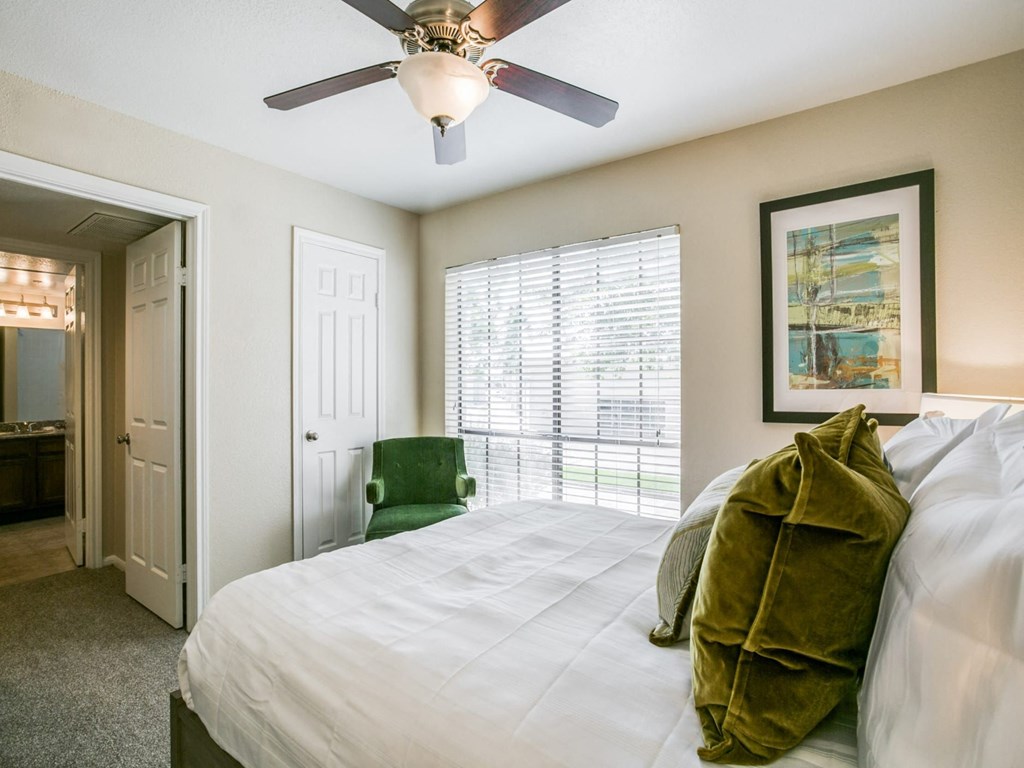 a bedroom with a large bed and a ceiling fan