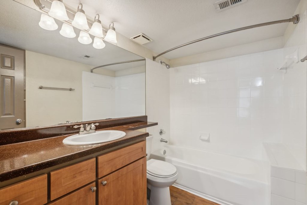 A bathroom with a sink, toilet, and bathtub.