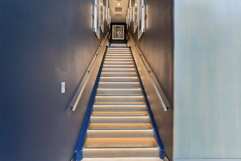 A long flight of stairs with a handrail on the left side.