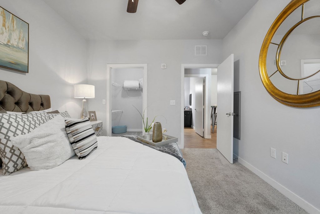 A bedroom with a large bed and a mirror on the wall.