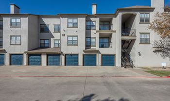 A large apartment complex with a parking lot in front.
