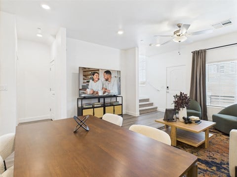 A modern dining room with a wooden table and chairs.