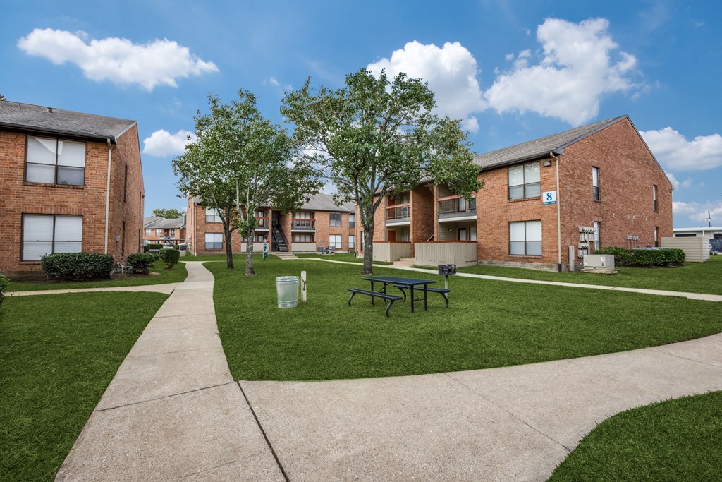 a rendering of a courtyard in front of a row of brick buildings